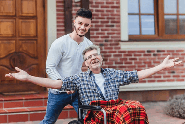 Male caregiver taking elderly person in wheelchair