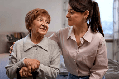Female caregiver hugging elderly women